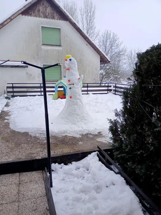 Big white snowman in the yard.