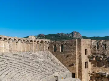 Roman theater of Aspendos Exterior facade of the stage building on the left with the upper bleachers and the arcade, in the background the foothills of the Taurus Mountains