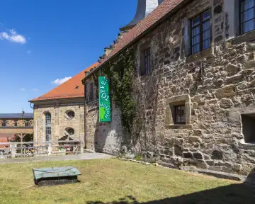The courtyard of the pottery museum in Thurnau with a view of the St. Laurentius church and the covered passage to the castle