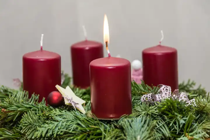Erste Kerze am tannengrünen Adventskranz brennt - Adventszeit
