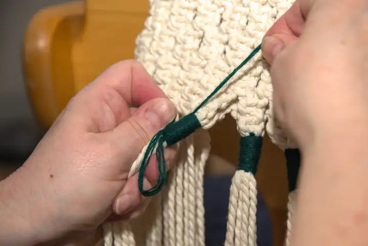 Handwork macramé - knotting technique with rope and sling knot, close up