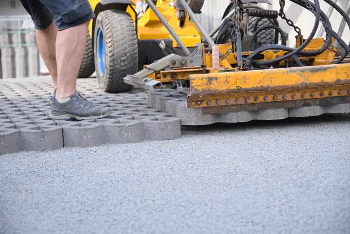 Laying grass pavers on construction site with construction machine - Construction industry