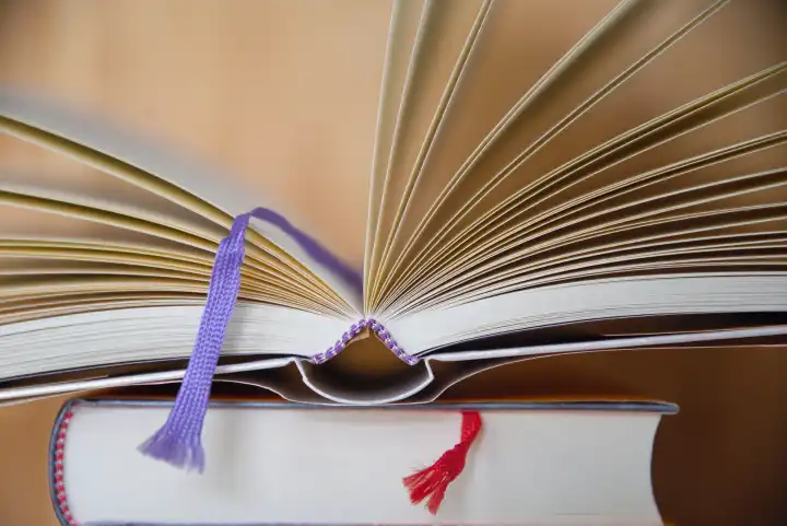 Fabric ribbon as bookmark - open book with notebook ribbon, closeup