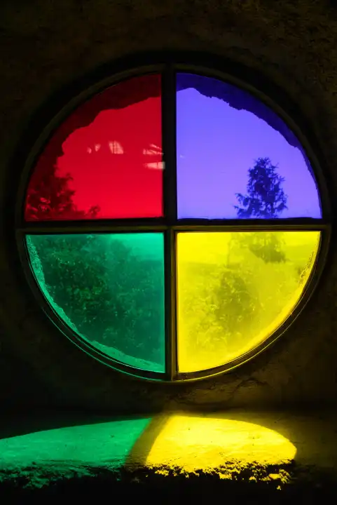 altes rundes Fenster mit vier kräftig leuchtenden Farben in altem Gebäude - Farbfenster