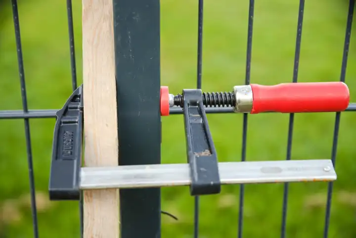Use a screw clamp to fix the garden fence during assembly work