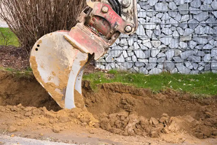 Excavator shovel during earthworks on the construction site - close-up