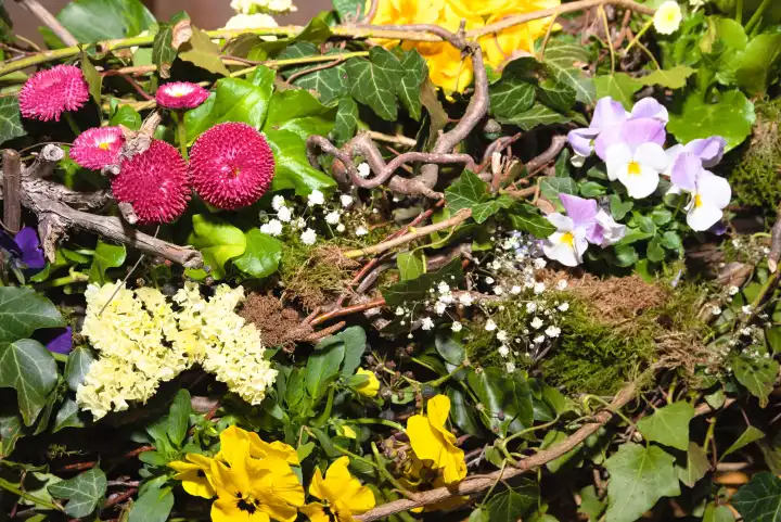 dekoratives Gesteck für den Frühling mit Weide, Moos und Blumen