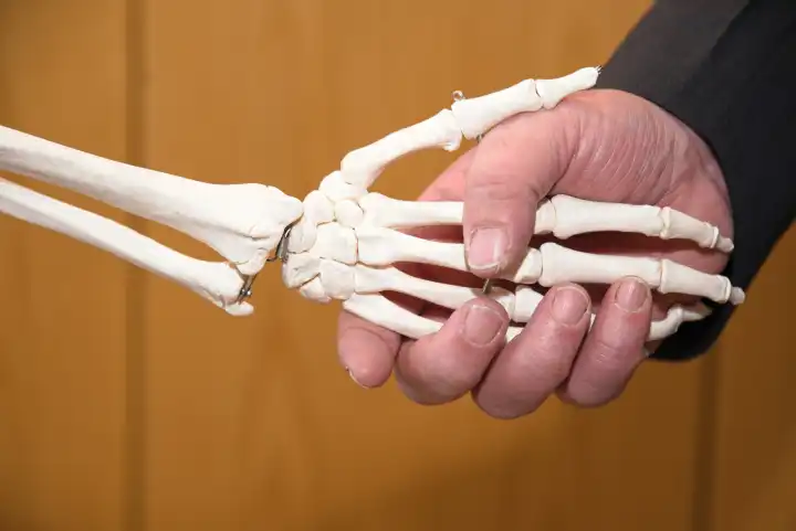 Greeting with a skeleton by shaking hands - close-up