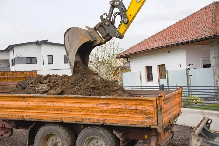 Baggerschaufel bei Erdauschub und Lastkraftwagen auf Baustelle - Nahaufnahme