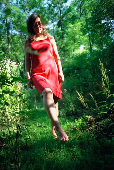 Woman with red dress goes for a walk