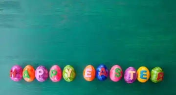 Colorful easter eggs with Happy Easter on rustic wooden background