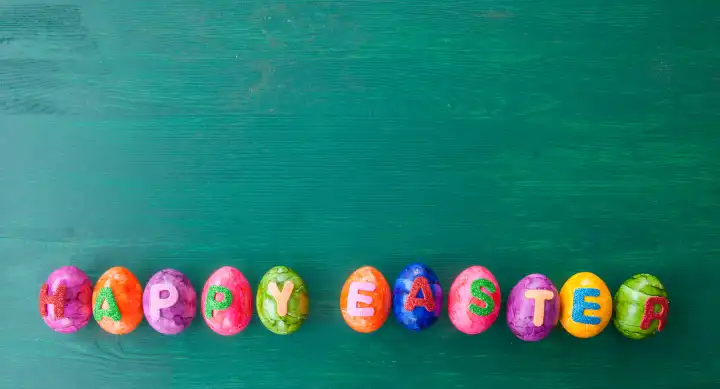 Colorful easter eggs with Happy Easter on rustic wooden background