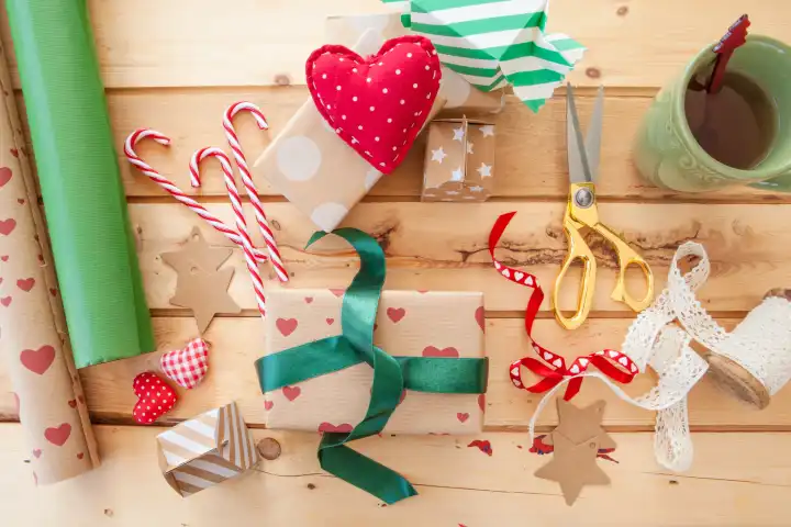 Geschenke zu Weihnachten verpacken auf rustikalem Hintergrund aus Holz