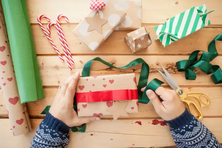 Geschenke zu Weihnachten verpacken auf rustikalem Hintergrund aus Holz