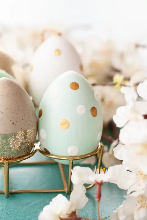 Fröhlich dekorierte Eier und weisse Blueten zu Ostern