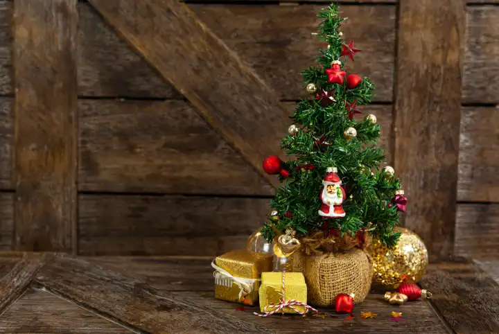 Kleiner dekorierter Christbaum / Weihnachtsbaum mit Geschenken zu Weihnachten
