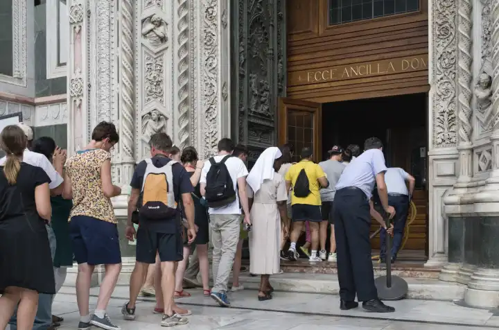 tourists queue to enter il duomo in florence italy
