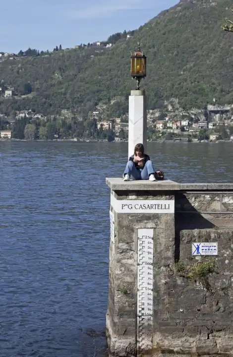 young woman reading a book in Torno, Lake Como, Italy