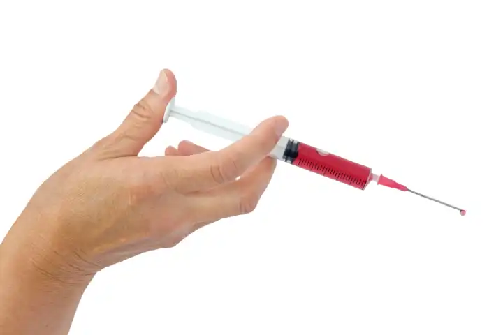 Hand hält eine Injektionsspritze