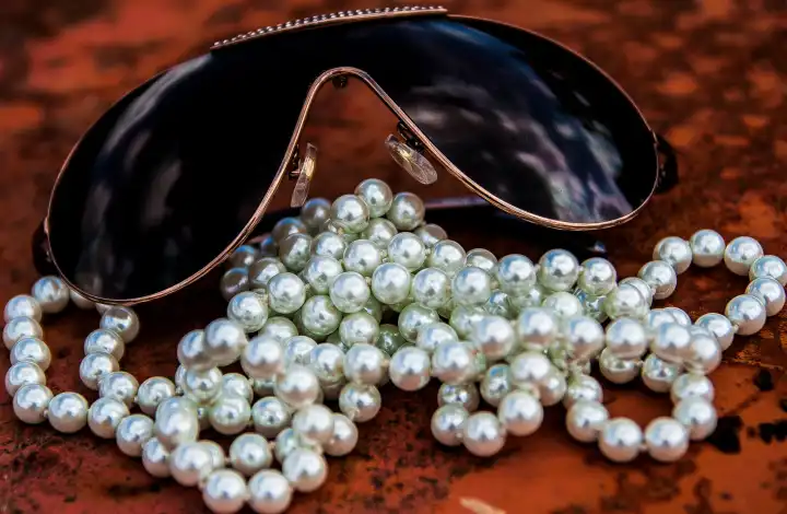 Sonnenbrille und Perlenkette