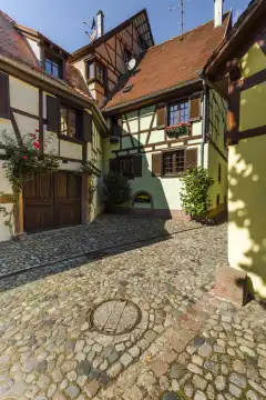 Malerische Gasse mit Fachwerkarchitektur in der Altstadt von Kaysersberg, Elsässer Weinstraße, Frankreich, bunte mittelalterliche Häuser, beliebter Touristenort