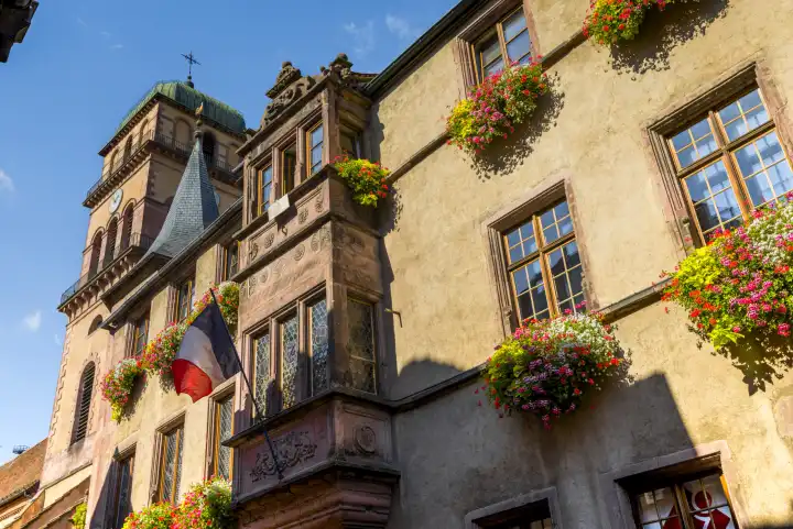 town hall of the village Kaysersberg, Alsace Wine Route, France, front with tricolor flag and flower decoration