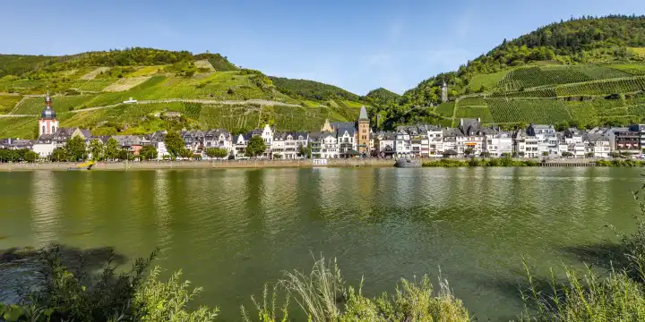 panorama of community Zell at the Moselle river, Germany, houses along the river bank with steep vineyards and Collis Tower