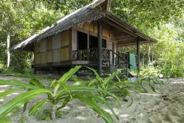 Bungalow in traditioneller Bauart umgeben von tropischer Vegetation. Selayar, Südsulawesi, Indonesien.