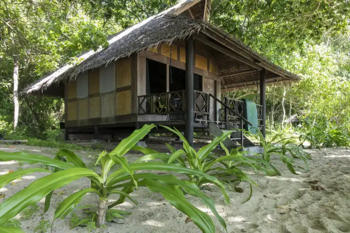 Bungalow in traditioneller Bauart umgeben von tropischer Vegetation. Selayar, Südsulawesi, Indonesien.