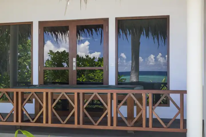 exterior view of a bungalow with sea reflection in the windows