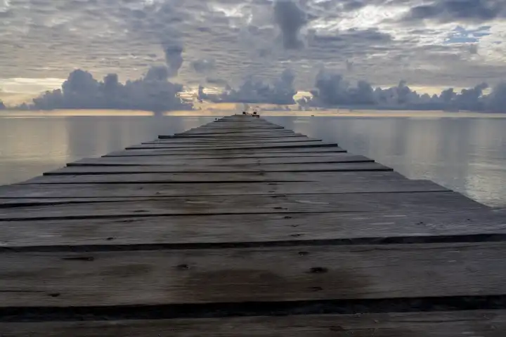 wooden jetty over a sea, smooth as a mirror, seems to lead to infinity