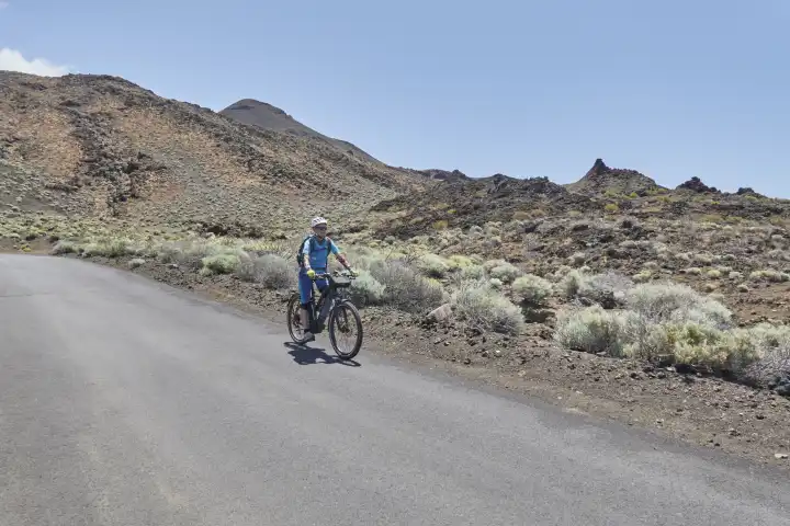 Mountainbikerin unterwegs in karger, vulkanisch geprägter Landschaft. El Hierro, Kanarische Inseln, spanien