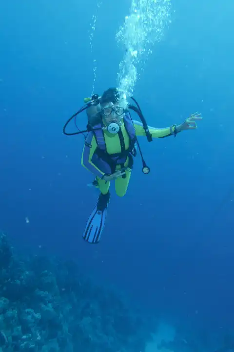 Diver gives ok signs underwater. Hurghada, Egypt