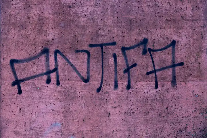 Antifa, gesprayte Schrift auf rosa Betonwand
