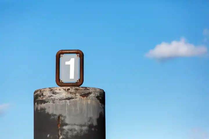 Number 1 on a cylindrical shape in front of a blue sky