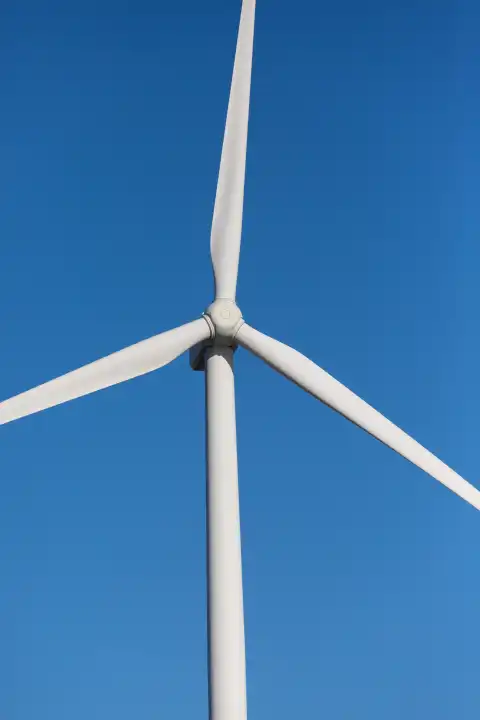 White wind turbine in front of a blue sky