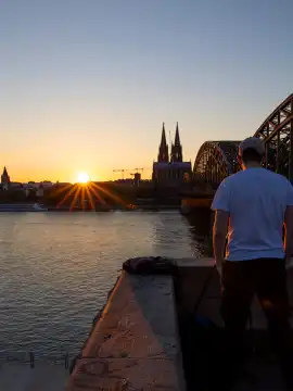 Blick von Köln-Deutz auf den kölner Dom , die untergehende Sonne und die Hohenzollernbrücke
