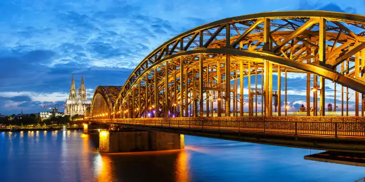 Cologne, Germany - August 3, 2021: Cologne Cathedral skyline and Hohenzollern Bridge with river Rhine in Germany at night panorama in Cologne, Germany.