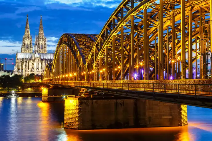 Cologne, Germany - August 3, 2021: Cologne Cathedral skyline and Hohenzollern Bridge with river Rhine in Germany at night in Cologne, Germany.
