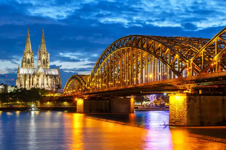Cologne, Germany - August 3, 2021: Cologne Cathedral skyline and Hohenzollern Bridge with river Rhine in Germany at night in Cologne, Germany.