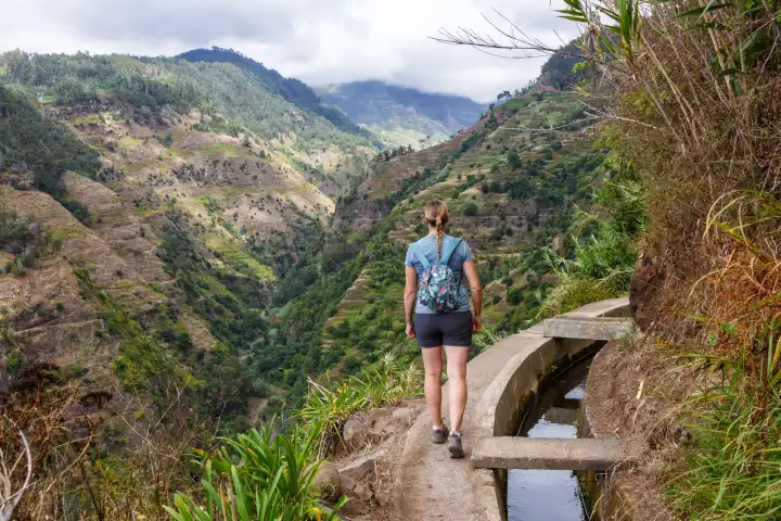Madeira, Portugal - 14. September 2022: Junge Frau wandert entlang der Levada Nova Wanderung wandern Wanderweg auf der Insel Madeira, Portugal.