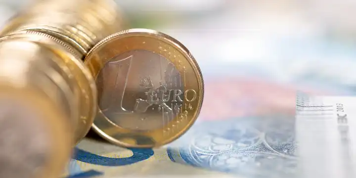 Stuttgart, Deutschland - 24. Februar 2023: Ein Euro Münze Geld sparen Finanzen zahlen bezahlen mit Textfreiraum Banner in Stuttgart, Deutschland.