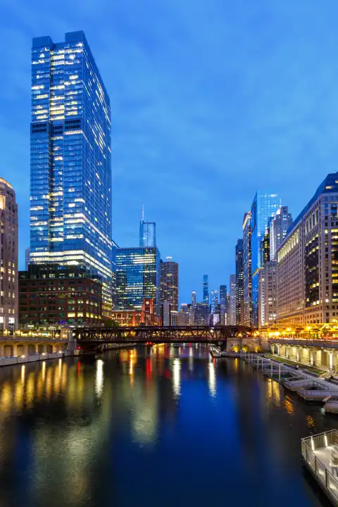 Chicago, USA - 3. Mai 2023: Skyline Wolkenkratzer Hochhäuser am Chicago River Brücke Hochformat bei Nacht in Chicago, USA.