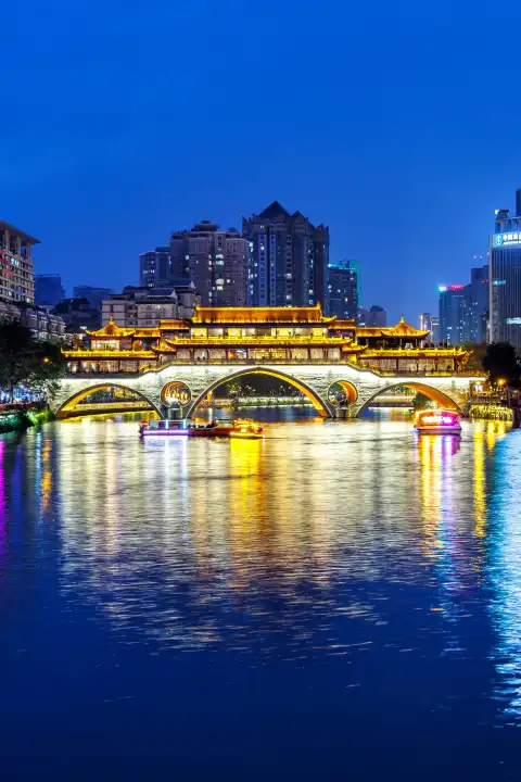 Chengdu, China - 7. April 2024: Chengdu Anshun Brücke über Fluss Jin mit Pagode Hochformat bei Nacht in Chengdu, China.
