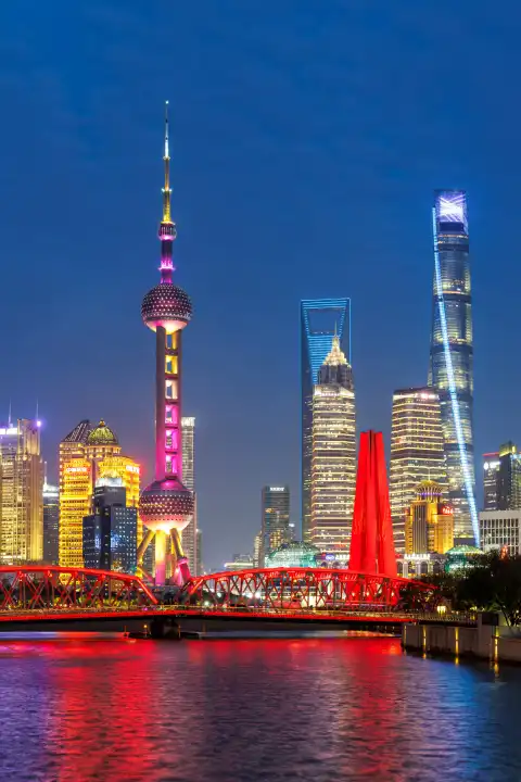 Shanghai, China - 10. April 2024: Shanghai Skyline am Bund mit Oriental Pearl Tower Innenstadt Downtown Hochformat bei Nacht in Schanghai, China.