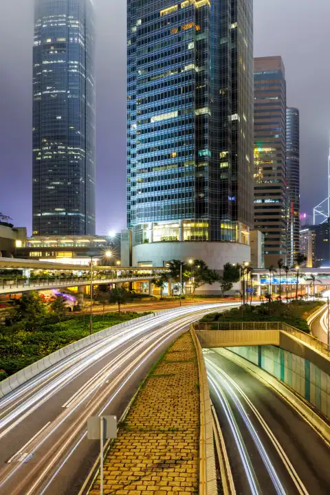Hongkong, China - 6. April 2024: Verkehr mit Straßen und Hochhäuser in der Stadt Hong Kong bei Nacht Hochformat in Hongkong, China.