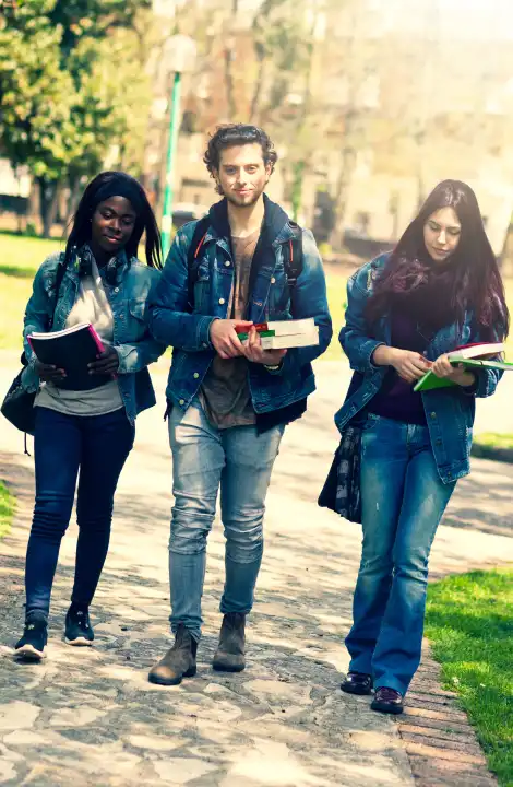 Three young students in the outdoor park Multiracial group concept