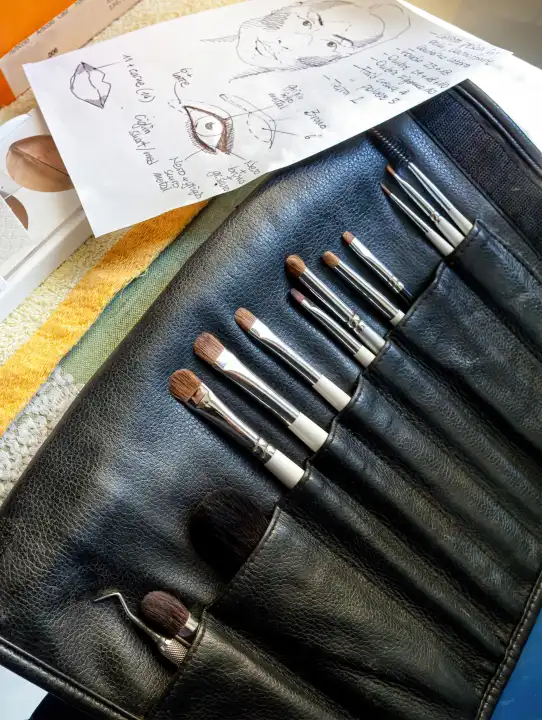 Make-up brushes with notes about the face to be made up