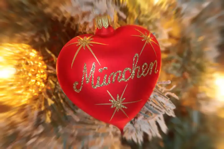 Christbaumkugel in Herzform mit Aufschrift München an einem beleuchteten Weihnachtsbaum