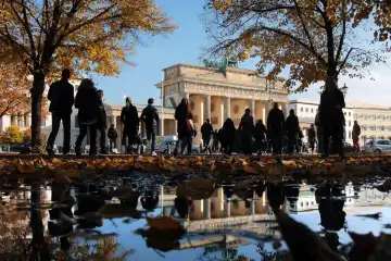 goldener Oktober in Berlin Brandenburger Tor spiegelt sich bei schönstem Herbstwetter in einer Wasserpfütze, Deutschland